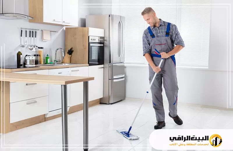 تنظيف السطح الخارجي للأجهزة بالرياض 0550071994 البيت الراقي رجل ينظف مطبخًا باستخدام ممسحة في الرياض