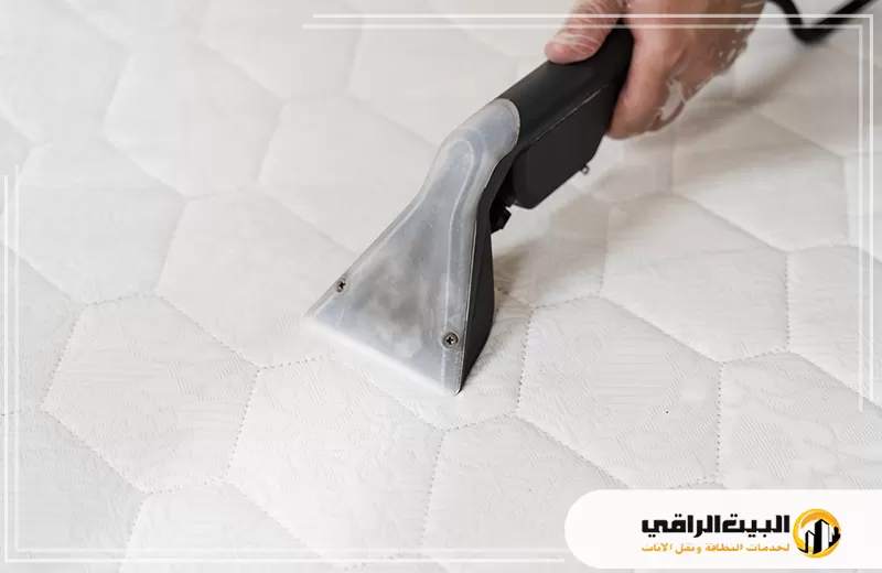 تنظيف مراتب بالبخار بالرياض 0550071994 البيت الراقي شخص يستخدم مكنسة كهربائية لتنظيف مرتبة سرير في الرياض.